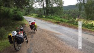 Two bikes parked along a quiet single-lane road. The caption alongside the picture reads, 'Ballater, Aberdeenshire'