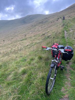 Walking our bikes down the steep and gravelly Cateran mountain trail path towards Dalmunzie hotel.